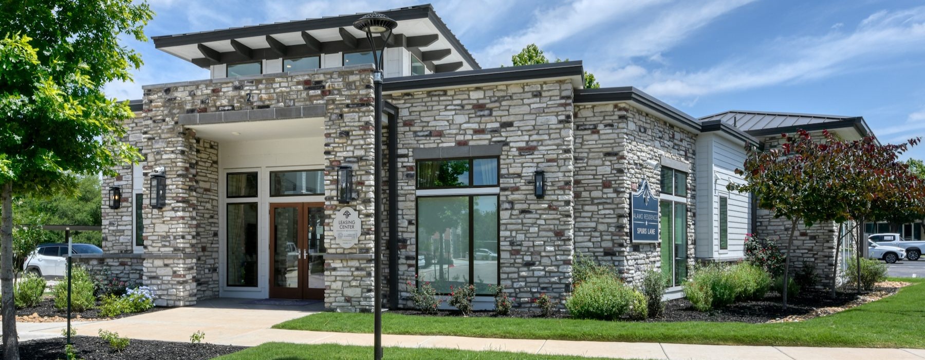 a brick building with a green lawn